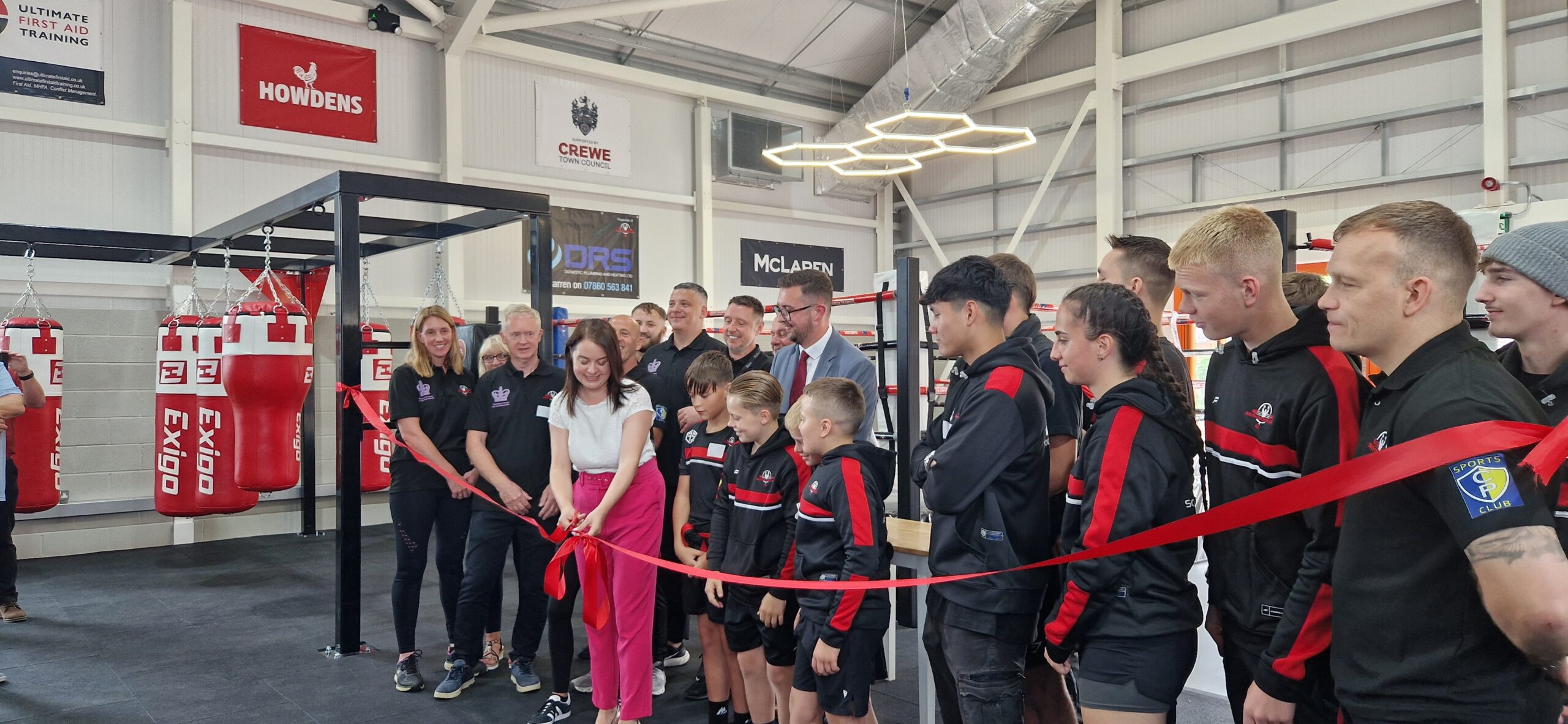 20250627_130642 Guests at the official opening of the new boxing gym facility at Mirion Street watch on as Stephanie Peacock MP cuts the ribbon.