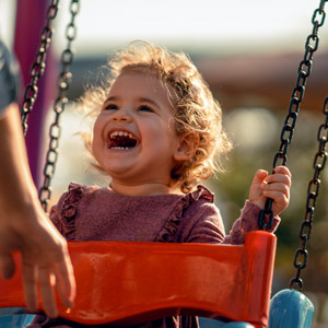 child laughing on a swing